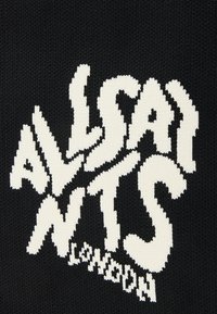 Svart stickad tyg med djärv vit text som säger "ALLSAINTS LONDON" i ett vågigt, stiliserat typsnitt. Stickad struktur är synlig.