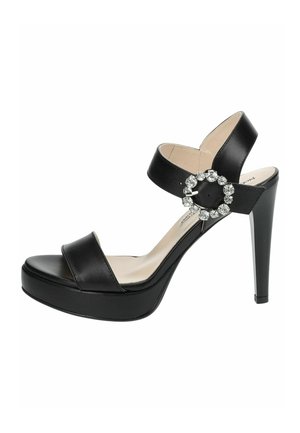 Black leather high-heeled sandals with a platform, featuring two straps over the foot and a circular jewel accent on the ankle strap.