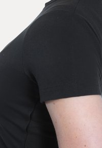 Sort T-shirt med korte ærmer, glat bomuldsblanding, tætsiddende pasform, med rund hals og syede ærmer, vist fra siden.