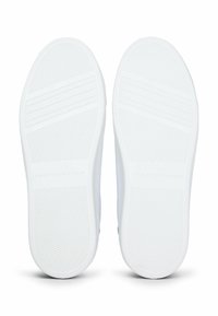 Soli delle sneaker bianche con scanalature orizzontali per una maggiore aderenza, con un sottile logo del marchio impresso sulla superficie. Design pulito e moderno.