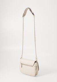 Beige læder crossbody taske med en buet form, der har en guldkæde-strop og en frontlomme med lynlås. Glat tekstur og rent design.