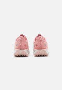 Baskets de sport roses avec une tige en mesh, détail texturé, languette au talon et semelle en caoutchouc dotée de motifs de traction multidirectionnels.