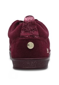 Burgundy suede sneaker with a textured, glossy back heel and gold hardware accent. Rubber sole with a patterned grip for traction.
