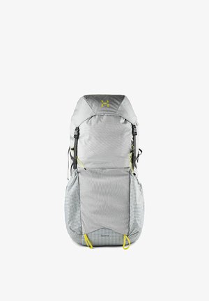 Sac à dos de randonnée gris clair avec des bretelles noires, des languettes jaunes et un motif en grille sur les poches basses et le fond.