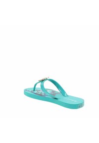 Chancla de color aqua con una suela texturizada y una plantilla con un diseño. Presenta una correa brillante con un acento decorativo en oro.