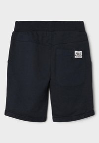 Marinblå bomullsshorts med ribbad midja, uppvikt fåll och en bakficka med ett varumärkesmärke. Slät textur med minimal detaljering.