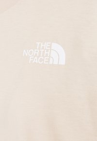 T-shirt in cotone beige con logo bianco e design a mezza luna. Tessuto morbido con scollo rotondo e maniche corte.