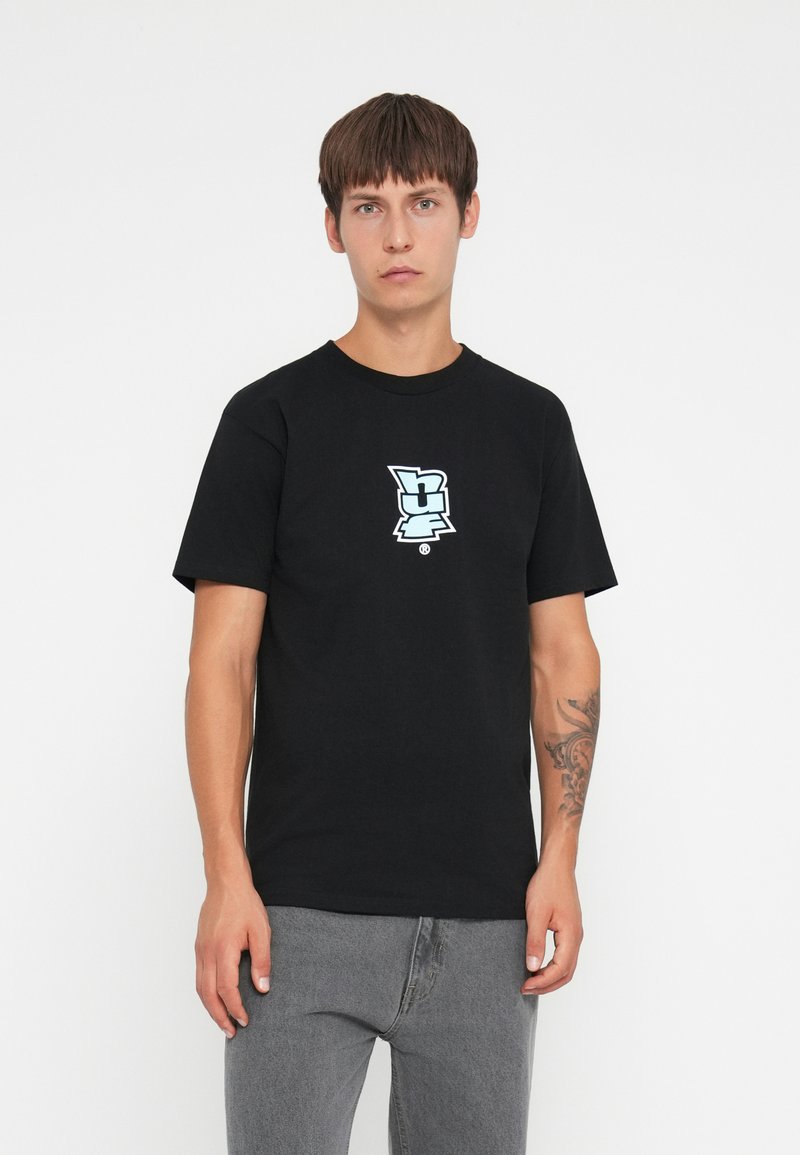 Black cotton t-shirt with short sleeves, featuring a light blue graphic logo at the center. The shirt has a relaxed fit and round neckline.