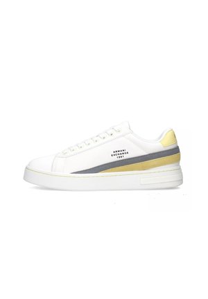 Sneaker in pelle bianca con accenti grigi e gialli, punta rotonda, suola piatta, logo stampato sul lato e chiusura con lacci.