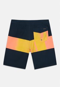 Námornícky modré plavky s horizontálnymi prúžkami v ružovej a žltej farbe. Obsahujú zadnú vrecko s uzatváraním na gombík a viditeľné švy.