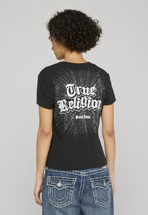 T-shirt nera a maniche corte con una stampa grafica bianca con linee raggianti e scritta "True Religion" sul retro. Materiale in morbido cotone.
