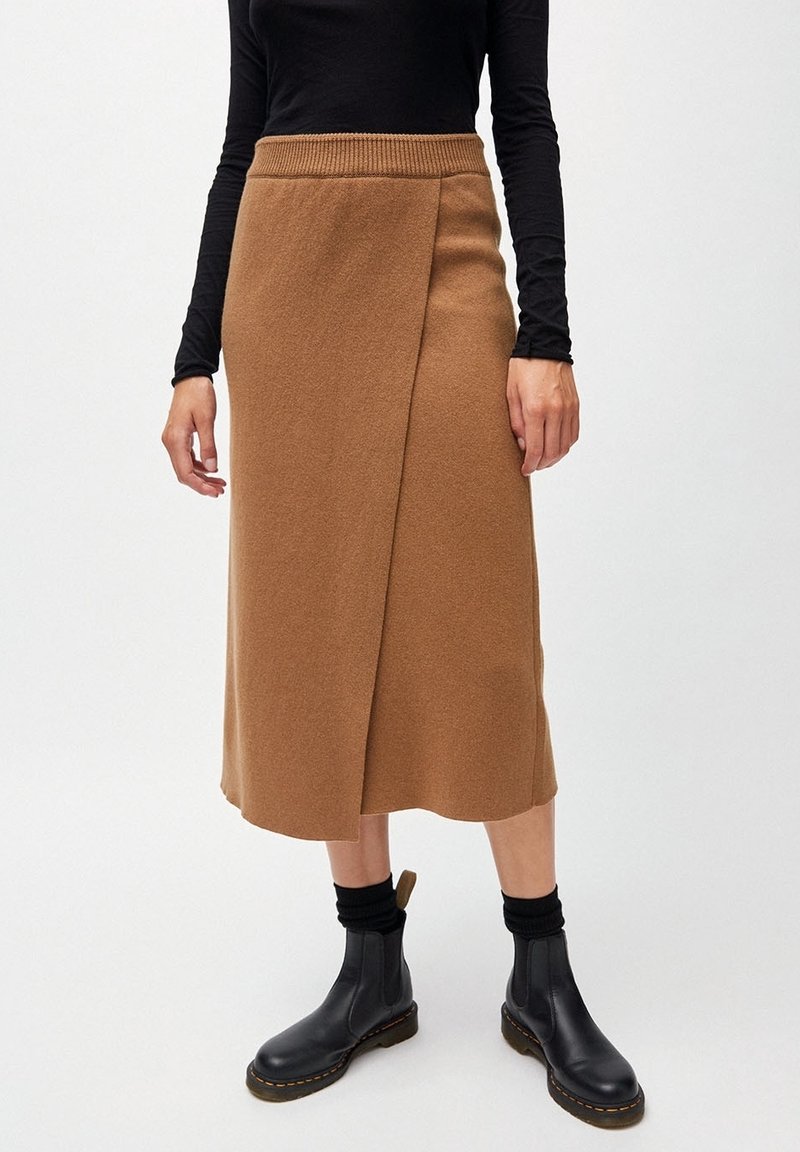 Brun, knälång omslagskjol med ribbad midjeband, visad med en svart långärmad topp och svarta ankle boots, med en mjuk, ull-liknande textur.