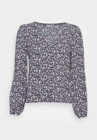 Blouse marine à manches longues, col en V et détails de boutons. Motif de fleurs roses et blanches sur un fond sombre. Tissu léger.