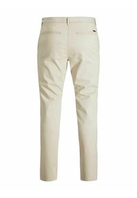 Lichtbeige broek met een slim fit, voorzien van twee achterzakken en een gladde textuur. De tailleband heeft riemlussen en discrete branding.
