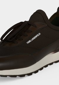 Ασπρόμαυρο sneaker Karl Lagerfeld με κορδόνια και υφή στη σόλα, με κείμενο λογότυπου στο πλαϊνό πάνελ.