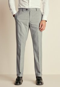 Pantalones gris tailored con una tela texturizada, con un corte slim, bolsillos laterales y un pliegue en la parte frontal para un aspecto pulido.