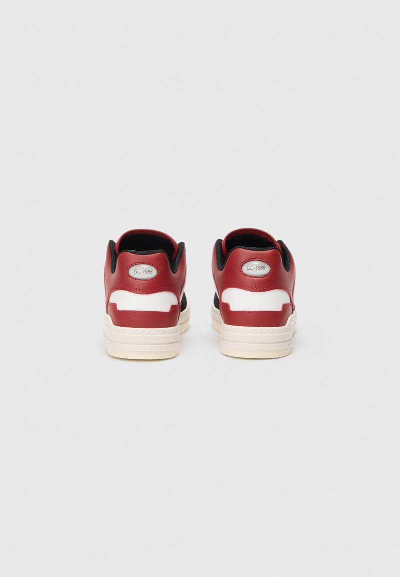 Baskets en cuir rouge avec des accents noirs, semelle intermédiaire blanche, col rembourré et une étiquette argentée portant la mention "GC-1988" au niveau du talon.
