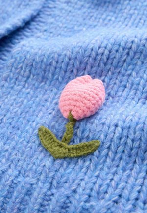 Material albastru tricotat cu un model texturat care include un lăstar croșetat roz în formă de lalea și tulpină verde, adăugând un element decorativ.