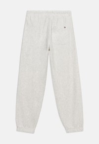 Ανοιχτό γκρι παντελόνι φόρμας από φλις με ελαστική μέση και μανσέτες στους αστραγάλους, που διαθέτει μια πίσω τσέπη με μικρό κόκκινο, λευκό και μπλε λογότυπο.