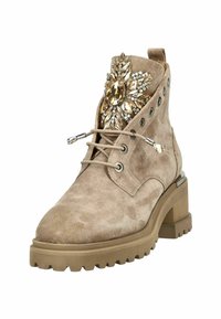 Botín de ante beige hasta el tobillo con frente de cordones, acento decorativo de joyas, tacón grueso y suela resistente con perfil de goma.