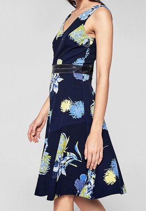 Floral dress with a navy background, featuring blue and yellow blooms, fitted bodice, V-neckline, and a black belt accent at the waist.