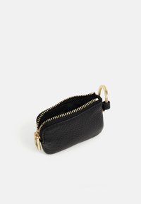 Borsetta per monete in pelle nera texture con zip e accessori in oro, presenta due scomparti e un attacco per chiavi. Design compatto e funzionale.