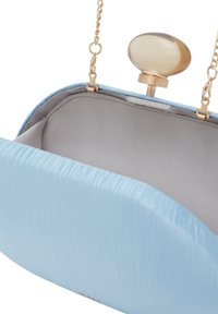 Světle modrá kabelka na ruku s hladkým povrchem, kulatým tvarem, zlatými doplňky, řetízkovým popruhem a oválným zámkem. Uvnitř je béžová látka.