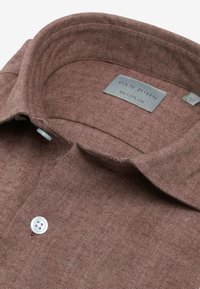 Brun skjorte med fiskebensmønster og struktureret krave, der har en hvid knap og en grå label, der står 'DAN JOHN REGULAR'.