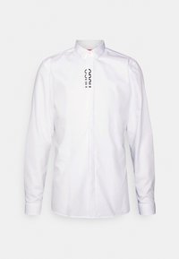 Witte longsleeve shirt van gladde stof, met een klassieke kraag en een verticale zwarte logo gedrukt op de voorkant.