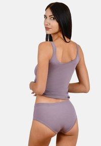 Top in cotone viola chiaro a maniche corte e slip coordinati. Il top ha spalline sottili e una vestibilità aderente, mentre gli slip presentano un design semplice e una copertura moderata.