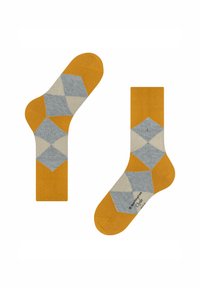 Due paia di calzini esposti: uno in posizione verticale, che mostra un motivo geometrico con rombi gialli, grigi e crema; l'altro girato di lato.