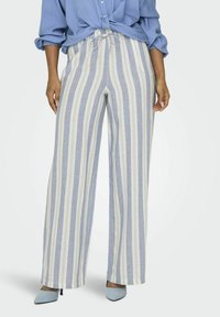 Lichte blauwe en crèmekleurige gestreepte broek met een wijde pijp, voorzien van een trekkoord in de taille en een gestructureerde afwerking. Gecombineerd met puntige schoenen.