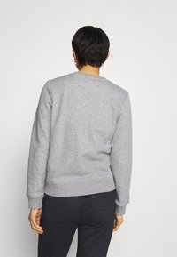 Grå crewneck sweatshirt med ribbede ærmeafslutninger og kant, lavet af blødt stof. Enkelt design uden synlige logoer eller mønstre.