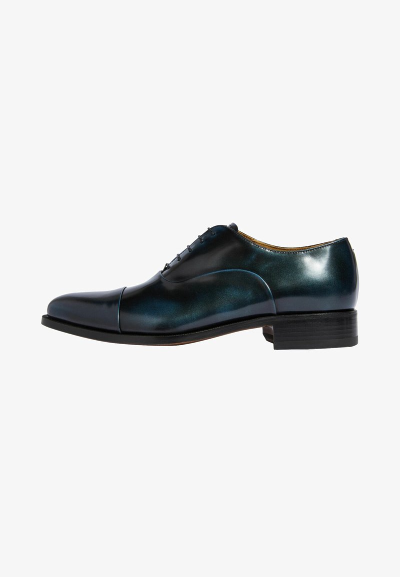 Zapato de vestir de cuero en azul oscuro con un acabado brillante. Presenta una puntera redondeada, diseño de cinco ojales con cordones y un tacón apilado.