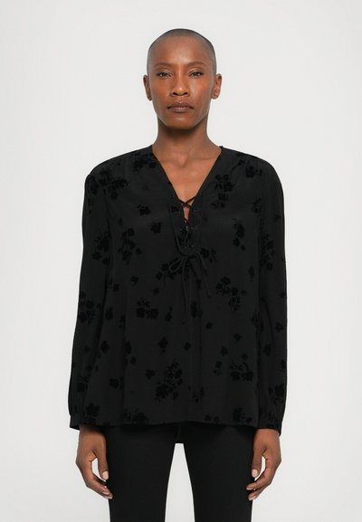 Black floral-pattern blouse with long sleeves, V-neckline, and lace-up front detail; made of smooth fabric with a subtle sheen.