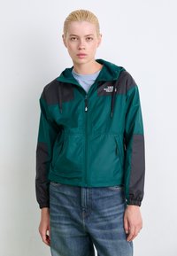 Teal en zwarte windbreaker jas met capuchon, rits aan de voorkant en twee zijzakken; voorzien van een logo op de borst en elastische manchetten.