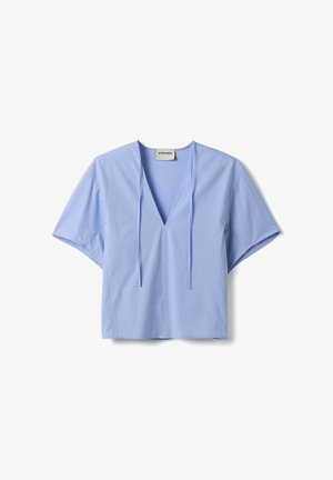 Lichtblauwe blouse met korte mouwen, diepe V-hals en voorstrikjes, gemaakt van gladde stof, weergegeven tegen een witte achtergrond.