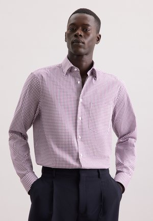 Geruite button-up overhemd in wit en kastanjebruin, van katoen, met lange mouwen, enkele borstzak, gedragen met donkerblauwe broek.