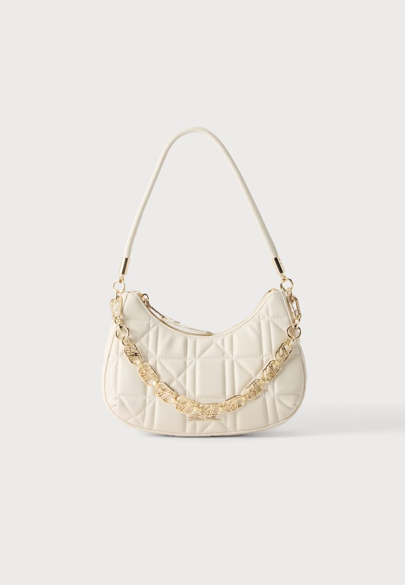 Petit sac à main matelassé crème avec une courte poignée et une chaîne dorée décorative à l'avant.