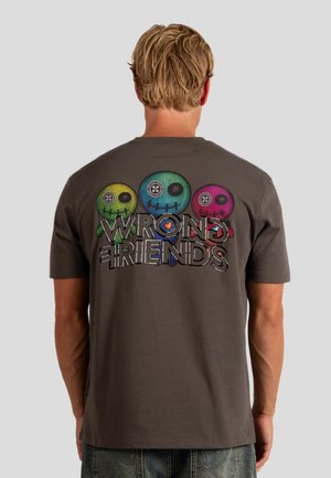 Gray cotton t-shirt featuring a colorful graphic of three stylized dolls on the back, with the text "WRONG FRIENDS" displayed prominently below.