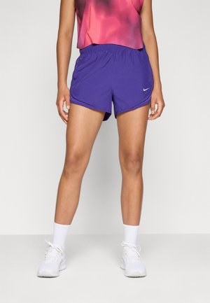 Nike purpursarkanie sporta šorti, kuriem ir elastīgs jostasvieta un viegls, elpojošs audums. Modelis apvienots ar baltām kedām un zeķēm.