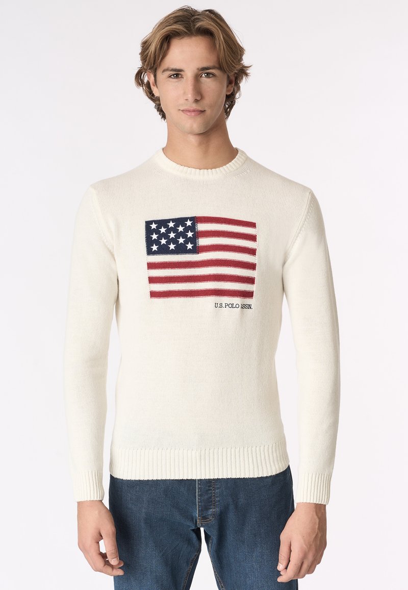 Maglione bianco lavorato a maglia con un design della bandiera americana sul petto, con accenti rossi e blu e polsini e orlo a coste.
