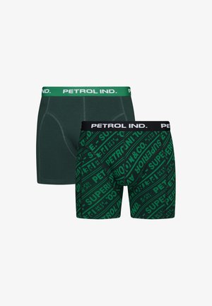 Groene boxershortset. Eén effen groen met contrasterende tailleband; de andere heeft een opvallend groen patroon met zwarte en witte branding.