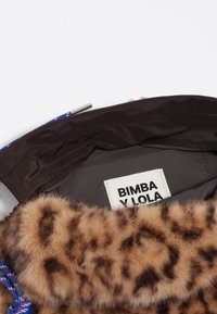 Brązowy płaszcz z futrzanym kołnierzem w wzór w panterkę. Posiada kolorowy sznurek do regulacji i metkę z napisem "BIMBA Y LOLA" wewnątrz. Miękka tekstura.