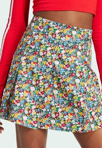 Falda plisada de estampado floral con flores multicolores sobre un fondo azul, que cuenta con una cinturilla y un sutil logo de la marca. Material de algodón.