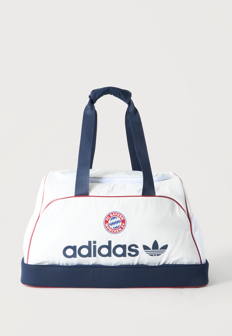 Άσπρη και ναυτικό μπλε αθλητική τσάντα Adidas με το λογότυπο της FC Bayern Munich, ναυτικό μπλε λαβές και κόκκινη ρίγα στις άκρες.