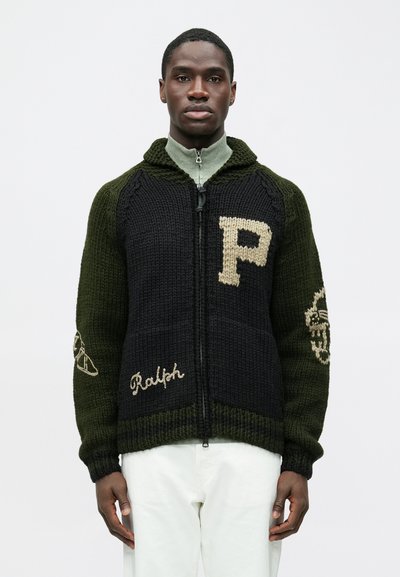 Gestrickter Pullover mit Reißverschluss vorne in Dunkelgrün und Schwarz, mit einem "P" und dem Schriftzug "Ralph" in Beige sowie dekorativen Akzenten an den Ärmeln.