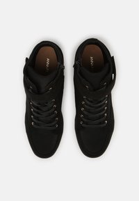 Svarta höga sneakers i mocka och mesh, med en texturerad ovandel, guldfärgade detaljer och snörning framtill med dragkedjestängning.