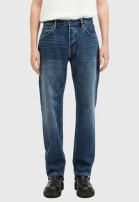 Jeans in denim blu scuro, con taglio dritto, design a cinque tasche e leggera scoloritura. Abbinati a stivali neri senza lacci.