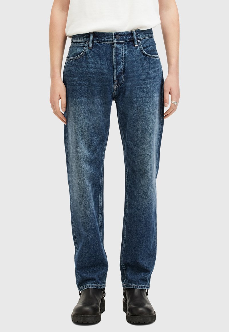 Jeans in denim blu scuro, con taglio dritto, design a cinque tasche e leggera scoloritura. Abbinati a stivali neri senza lacci.